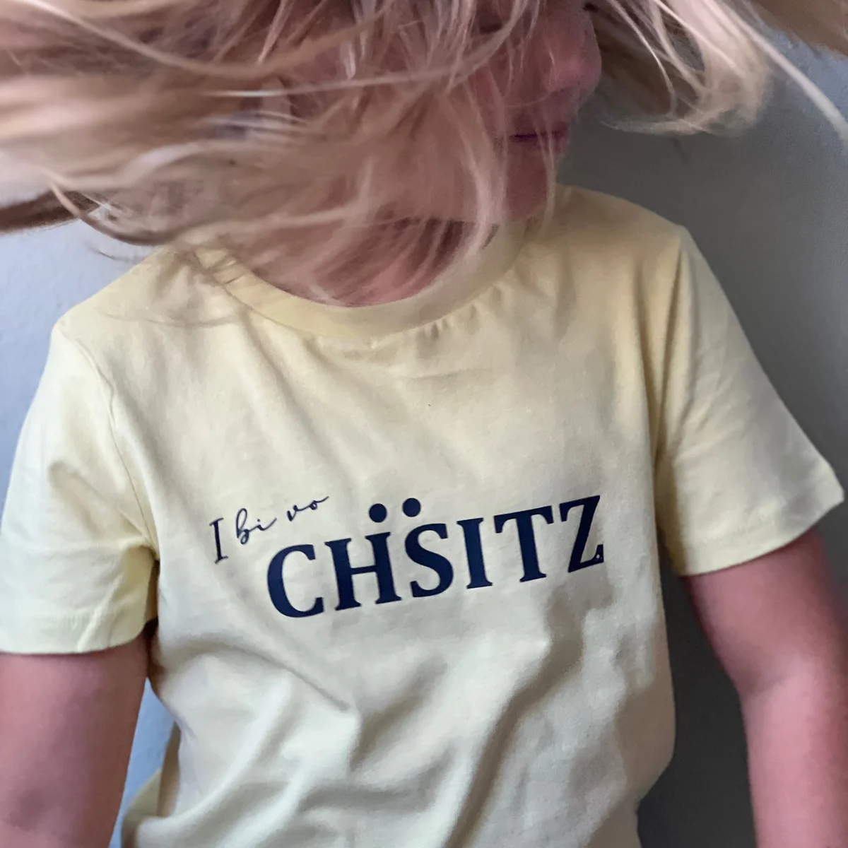 Kind in einem Shirt mit dem Schriftzug I bi vo Chäsitz